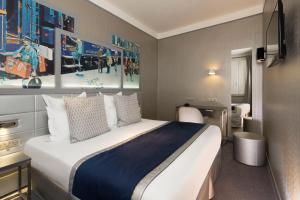 a hotel room with a bed and a painting on the wall at Palym in Paris