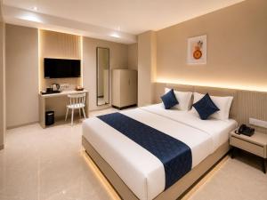 a bedroom with a large bed and a desk at Fun Hotels Gandhinagar in Gandhinagar