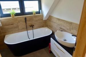 a bathroom with a bath tub and a sink at Chaty Korňa in Predmerská +10 photos