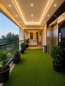 an office building with a green lawn on the balcony at Fun Hotels Gandhinagar in Gandhinagar