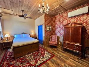a bedroom with a bed and a dresser and a chair at The Russ House in Tombstone