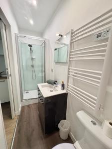 a white bathroom with a shower and a sink at Coudert VI l Petit Studio Climatisé Hyper Centre in Castres