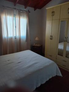 a bedroom with a large white bed and a dresser at Olloqui Dpto in Villa Mercedes