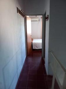 a hallway with a door to a room with a bed at Olloqui Dpto in Villa Mercedes