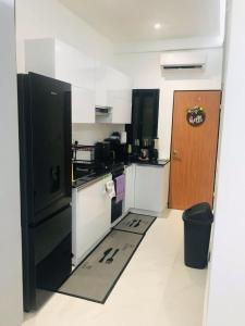 a kitchen with a black refrigerator and a door at NewAge Smart 2 in Ikeja