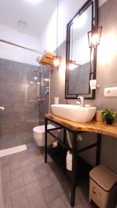 a bathroom with a sink and a toilet and a mirror at Hotel Antigone in Tirana +63 photos