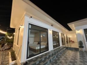 a house with a balcony with a bed in it at Hải Đảo Homestay in Quan Lạn