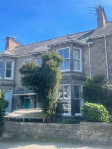 an old brick house with a bench in front of it at Penzance Central 1 & 2 Bedroom flats in Penzance