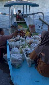 a group of people sitting on a boat with produce at Lombok eco Bungalow in Gili Gede