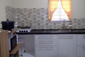 a kitchen with a sink and a stove at 3 Bed House - Sleeps 4 - Parking - Enclosed Garden in Paramaribo