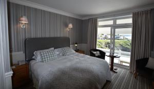 a bedroom with a bed and a large window at Watersmeet Hotel in Woolacombe