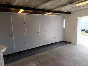 a row of white lockers in a garage at Frifelt Kro Almost Glamping telt in Frifelt