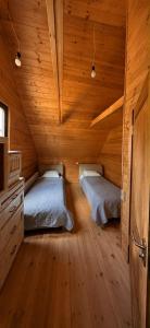 a bedroom with two beds in a wooden cabin at Bakhmaro Eco Cottage in Chʼkhakoura
