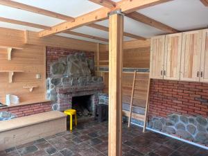 a room with a stone fireplace in a house at Bakhmaro Eco Cottage in Chʼkhakoura