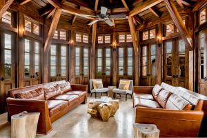 a living room with leather couches and a ceiling fan at Las Catalinas Doorway in Playa Flamingo