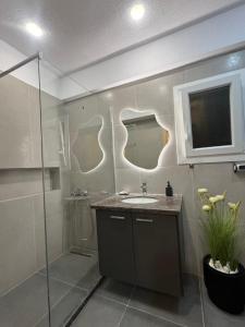a bathroom with a shower and a sink and a mirror at Downtown ViAlla Studio in Chios