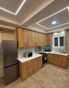a kitchen with wooden cabinets and a stainless steel refrigerator at Downtown ViAlla Studio in Chios