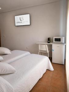 a room with two beds and a table with a microwave at Urban Suite in Los Alcázares