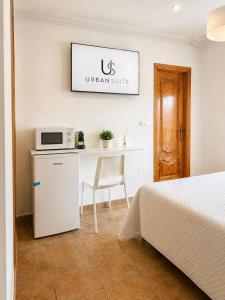 a room with a bed and a table with a microwave at Urban Suite in Los Alcázares +1 photo