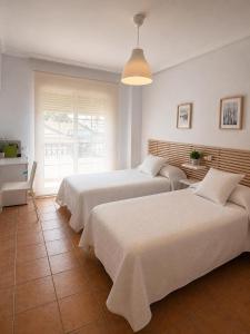 a bedroom with two beds and a window at Urban Suite in Los Alcázares