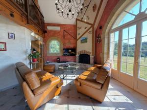 a living room with leather furniture and a fireplace at Ticoulat in Monein