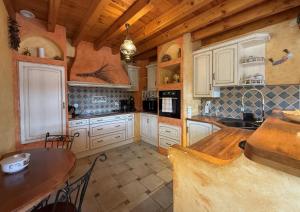 a kitchen with white cabinets and a wooden ceiling at Ticoulat in Monein