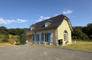 a small stone house with a black roof at Ticoulat in Monein