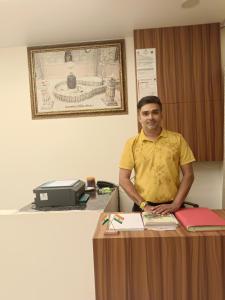 a man standing in front of a desk at Hotel Bhagwati Palace in Ujjain +7 photos