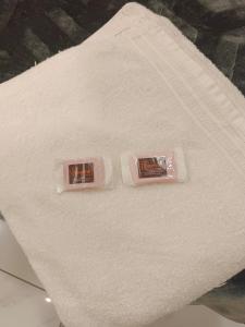 two packets of toothpaste sitting on top of a white towel at Hotel Bhagwati Palace in Ujjain