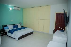 a bedroom with a bed and a flat screen tv at Résidence Touraco in Abidjan +39 photos