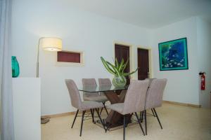a dining room with a glass table and chairs at Résidence Touraco in Abidjan