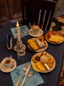 a table with plates of bread and coffee and a candle at Palazzo Diamante in Calascio