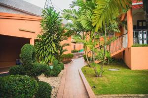 a garden with plants and a walkway in front of a building at Résidence Touraco in Abidjan