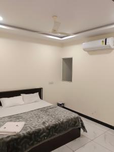 a bedroom with a bed and a ceiling at Hotel Bhagwati Palace in Ujjain