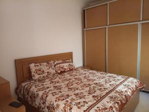 a bedroom with a large bed with a wooden headboard at house dream in Berkane