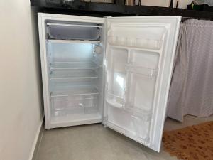 a white refrigerator with its door open in a room at Jacuzzi Privativa, Chalé Romântico com Decoração in Monte das Gameleiras