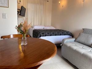 a living room with a table and a couch at Jacuzzi Privativa, Chalé Romântico com Decoração in Monte das Gameleiras