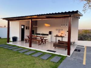 a pavilion with a ping pong table and benches at Jacuzzi Privativa, Chalé Romântico com Decoração in Monte das Gameleiras