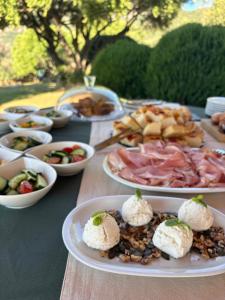 a table with plates of food on a table at Stazzu Barecca B&B in Cugnana Verde +9 photos
