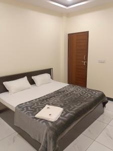a bedroom with a large bed with a tray on it at Hotel Bhagwati Palace in Ujjain