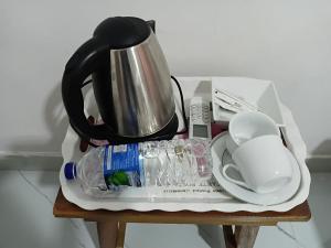 a tea pot and a water bottle on a table at Sigiri Rew Haven in Sigiriya