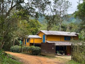 a house in the middle of a dirt road at Pousada Tiê-Sangue in Iporanga