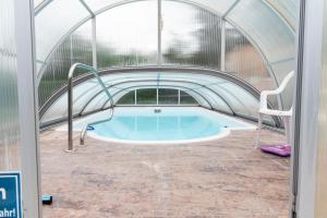ein Pool in einem Gewächshaus mit Whirlpool in der Unterkunft Ferienhaus WaldPeter bei CaroGrün in Erfurt-gemütlich-sonnig-Garten-Parken-Pool-Sauna-WLAN in Erfurt