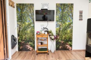 ein Wohnzimmer mit einem Wandbild von Bäumen in der Unterkunft Ferienhaus WaldPeter bei CaroGrün in Erfurt-gemütlich-sonnig-Garten-Parken-Pool-Sauna-WLAN in Erfurt