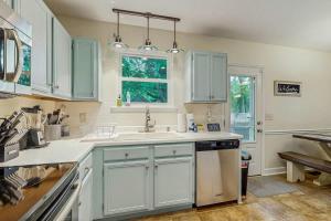 a kitchen with white cabinets and a sink and a window at Rustic Retreat in Franklin
