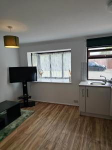 an empty living room with a piano and a window at Chilux in Rainham +8 photos
