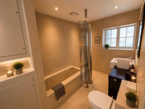 a bathroom with a shower and a toilet and a tub at The Stalls Suite at Strattons in Swaffham