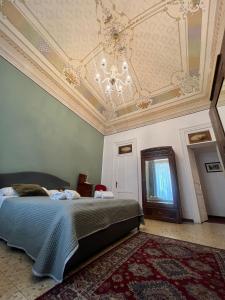 a bedroom with a bed and a ceiling with a chandelier at DS Apartment in Catania