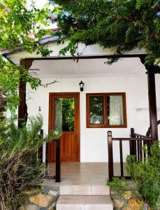 a small white house with a wooden door at Petrinos Butik Otel in Datca