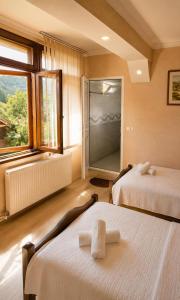 a hotel room with two beds and a large window at Teo Guesthouse and Camping in Mestia in Mestia +73 photos